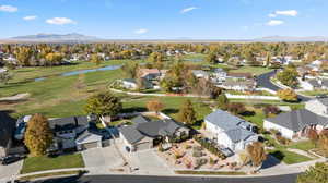 Aerial overview of property's location with nearby suburban area, a water and mountain view, and a golf club