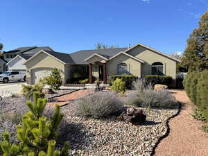 Ranch-style home with stucco siding, a garage, and concrete driveway