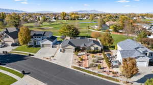 Aerial perspective of suburban area featuring a golf course and a water and mountain view
