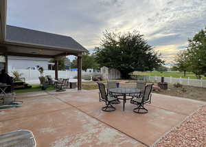Fenced backyard featuring outdoor dining area, a patio, and a storage shed