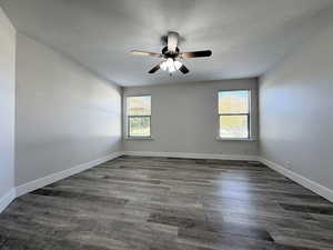 Unfurnished room featuring plenty of natural light, dark wood-style flooring, a textured ceiling, and a ceiling fan