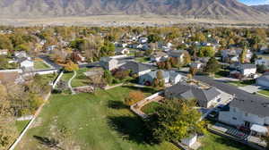 Aerial view of property and surrounding area featuring a mountain backdrop and nearby suburban area