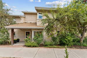View of front of property featuring stucco siding and roof with shingles