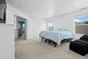 Bedroom with light carpet and recessed lighting