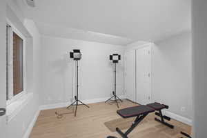 Exercise area featuring baseboards and light wood finished floors