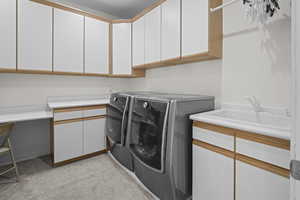 Laundry room featuring washer and clothes dryer, cabinet space, and light colored carpet