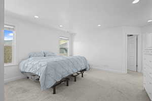Bedroom featuring multiple windows, recessed lighting, and light colored carpet