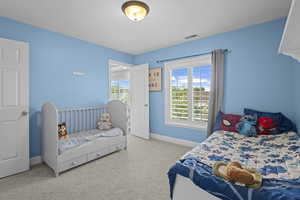 Bedroom featuring carpet and baseboards