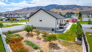 View of side of property featuring a fenced backyard, a patio, a mountain view, and stucco siding