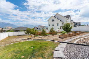 View of home's exterior with a garden, a fenced backyard, a mountain and lake view.