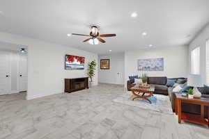 Living area with recessed lighting, a ceiling fan, and light marble finish floors