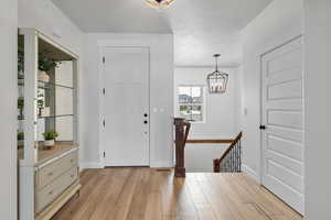 Foyer with a chandelier and light wood finished floors