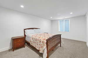 Bedroom with light colored carpet and recessed lighting