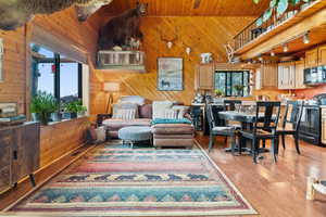 Living area featuring wood ceiling, wood walls, light wood-style flooring, and rail lighting