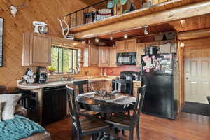 Kitchen with light countertops, black appliances, dark wood-style flooring, a wood ceiling with exposed beams, and rail lighting