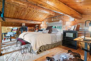 Bedroom featuring wooden ceiling, wood-type flooring, and wooden walls