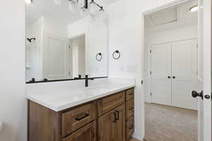 Bathroom with vanity and light carpet