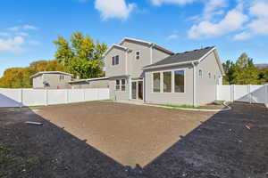Rear view of house with a fenced backyard, a gate, a patio, and roof with shingles