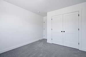 Unfurnished bedroom with carpet and a closet