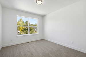 Spare room with light colored carpet and baseboards