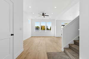Unfurnished living room featuring light wood-type flooring, recessed lighting, stairway, and ceiling fan