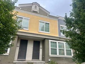 View of front of house featuring covered porch and stucco siding