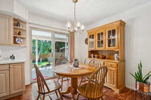 Dining room with a chandelier and dark wood-style floors
