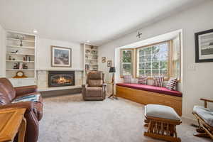 Living area featuring a premium fireplace, carpet, built in shelves, and recessed lighting