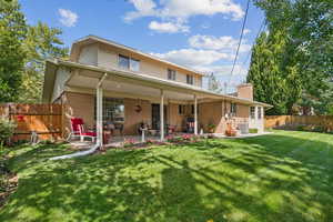 Rear view of house with a patio, a chimney, and brick siding