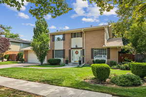 View of front facade featuring an attached garage, concrete driveway, and brick siding