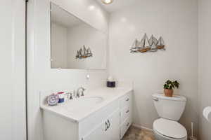 Half bathroom featuring vanity and toilet