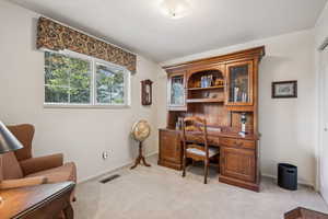 Office space with light colored carpet and baseboards
