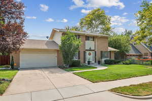 Traditional home featuring a garage, concrete driveway, brick siding, and a shingled roof