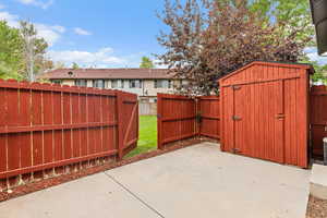 Fenced backyard with a shed and a patio