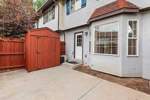 View of exterior entry featuring stucco siding and a patio area