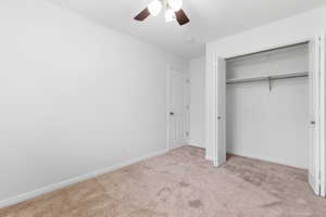 Unfurnished bedroom featuring light carpet, a closet, and ceiling fan