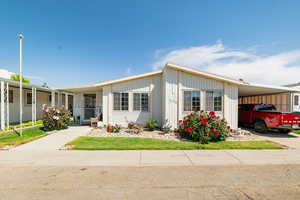 Manufactured / mobile home featuring an attached carport and driveway