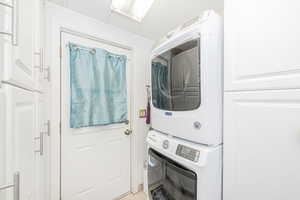Laundry room featuring estacked washer and dryer and light tile patterned floors