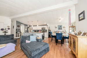 Living area featuring light wood finished floors and beam ceiling