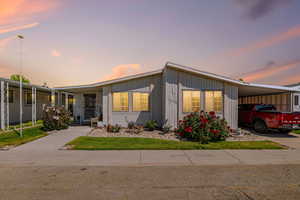 Manufactured / mobile home with an attached carport, concrete driveway, and board and batten siding