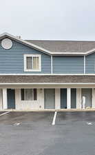View of front of property with a shingled roof and board and batten siding