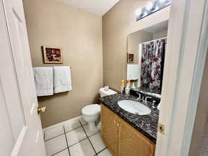 Bathroom featuring vanity, light tile patterned flooring, a textured ceiling, and curtained shower