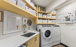 Laundry area featuring separate washer and dryer, light wood finished floors, and cabinet space