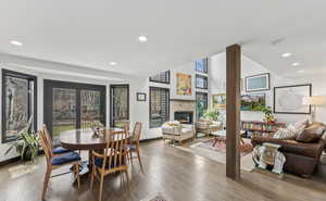 Dining space featuring recessed lighting, wood finished floors, and a glass covered fireplace
