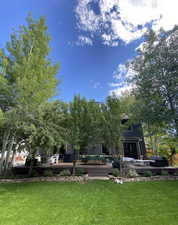 View of grassy yard featuring an outdoor living space and a wooden deck