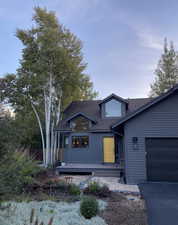 View of front of property with a garage and a shingled roof