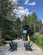 View of home's community featuring a playground, view of scattered trees, and a patio