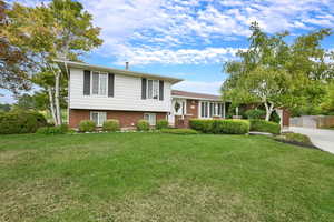 Split level home featuring brick siding and concrete driveway