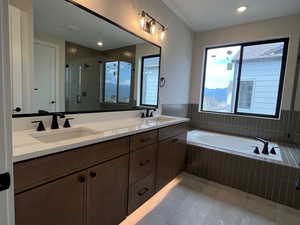 Full Primary bathroom with a stall shower, double vanity, a garden tub