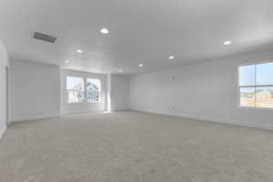Empty room featuring light carpet and recessed lighting